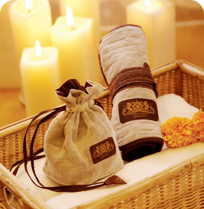 Suryagarh potli pouches and candles arranged in a woven basket